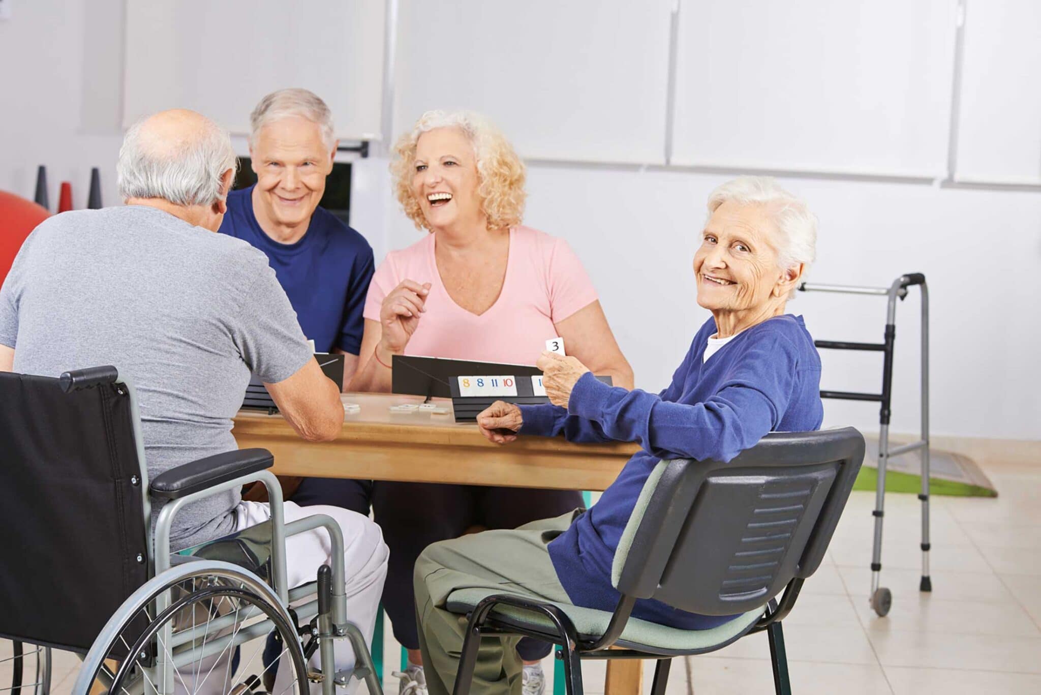 Fröhliche Senioren beim Spielen am Tisch in der Tagespflege